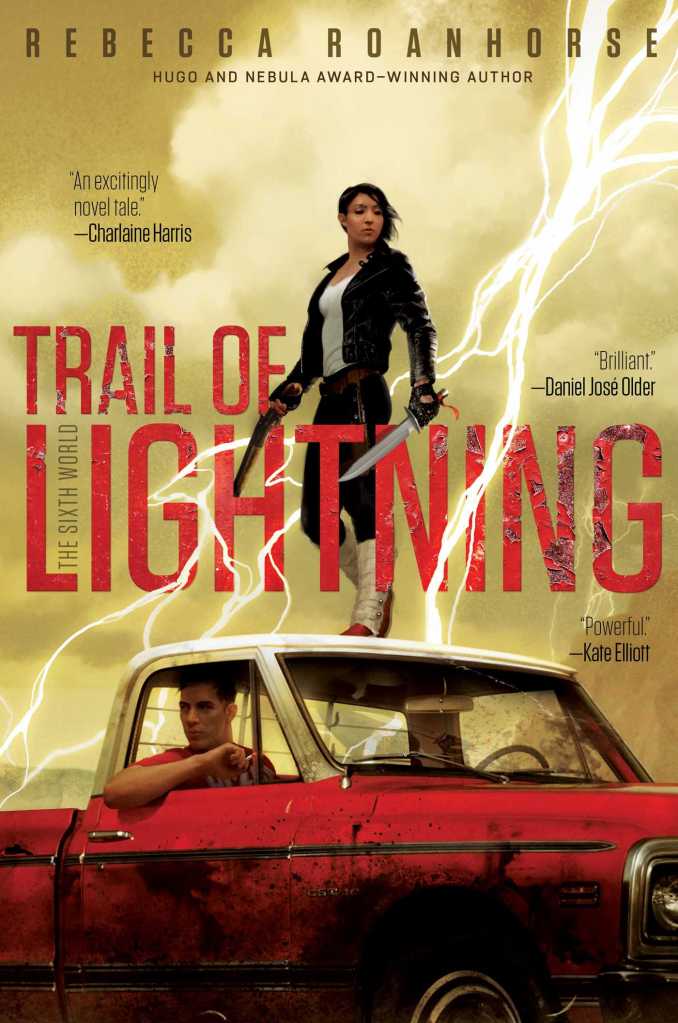 A Navajo woman dressed in jeans, leather jacket, and tradition Navajo footwear and wrappings stands on the roof of an old red pickup truck, holding a shotgun and a long knife. Lightnight arcs across the image, with dust yellow storm clouds behind.
