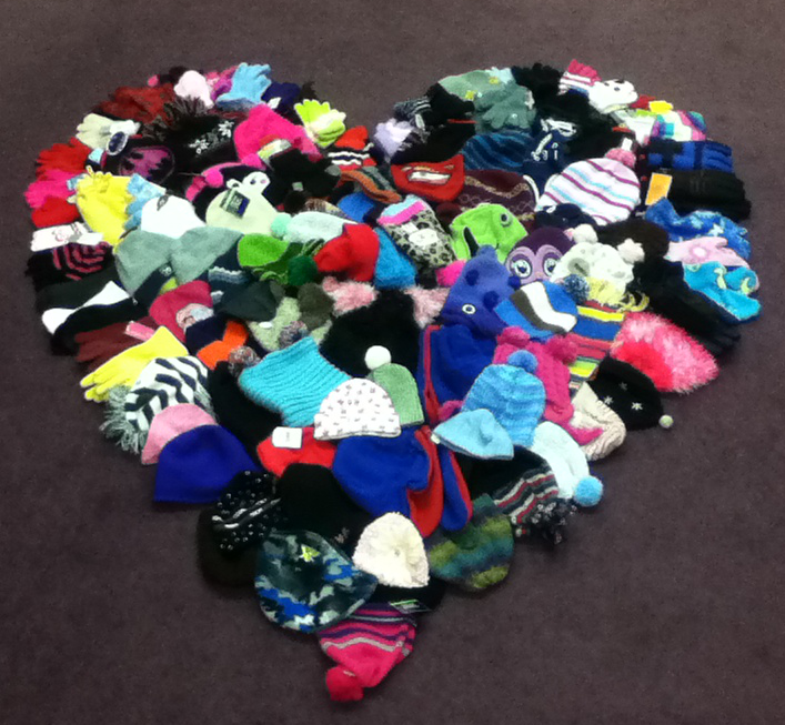 Lots of hats, mittens, and gloves form the shape of a heart.