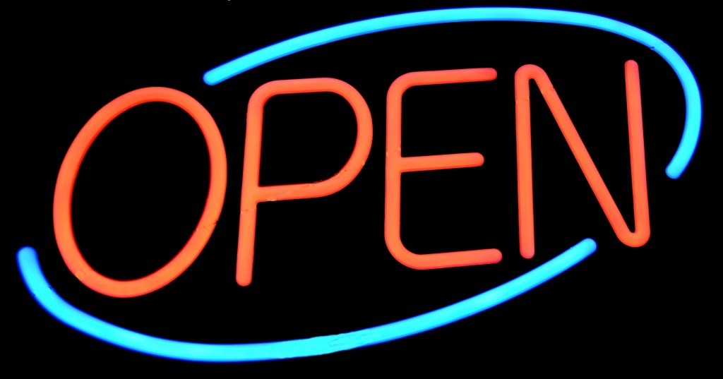 Neon sign with a bright blue oval encircling the word OPEN in red.