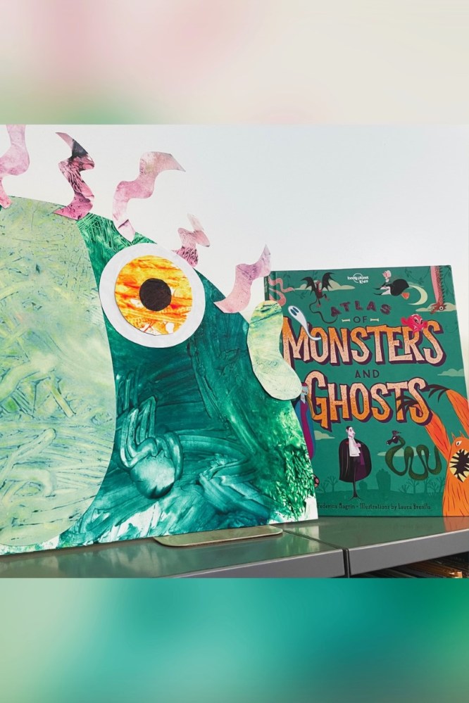 The picture depicts a teal-colored fish-like monster with a yellow eye next to the book, which has a teal color and depicts a variety of monsters, including dragons, snakes, and Dracula.