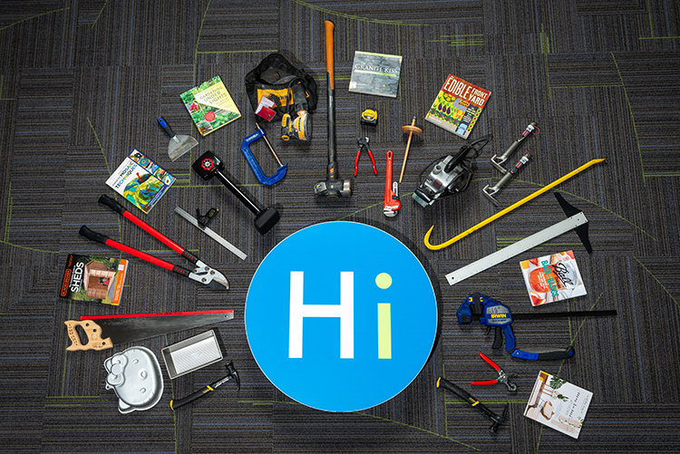 The blue Hi circle from the Library's logo lays on the floor surrounded by tools and books from the DIY collection.