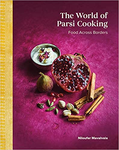 The cover of The World of Parsi Cooking shows a pomegranate with a bowl of dip, and various spices and seeds including cinnamon sticks and cardamom pods, against a bright pink tablecover.