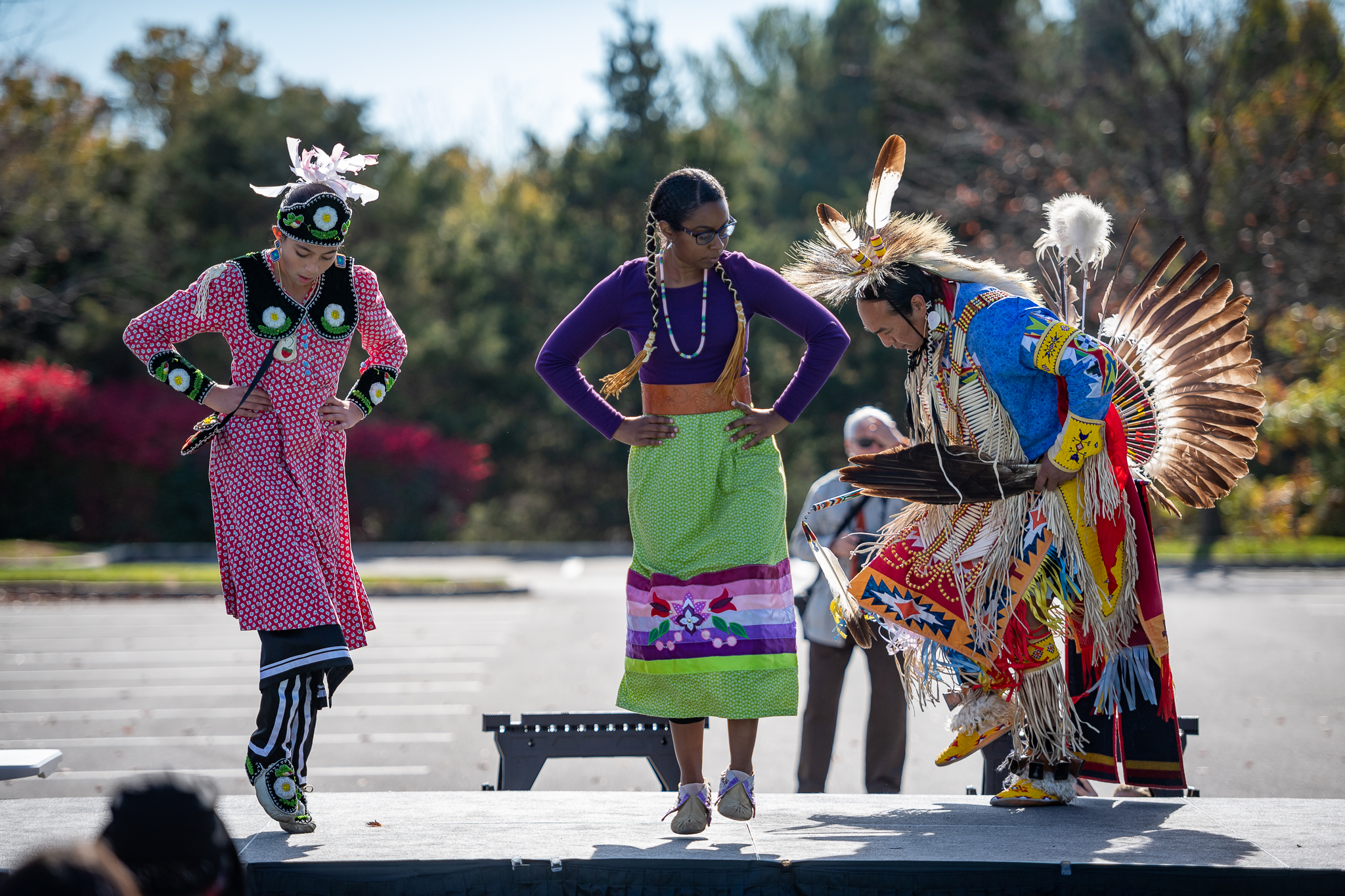 Three Native American dancers in traditional costume danicng at the Native American Heritage Celebration held at the East Columbia Branch Library in the fall.
