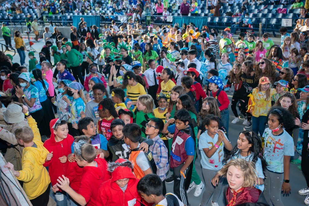 A crowd of fifth-graders dressed in colorful costumes talk excitedly while at Battle of the Books 2022.