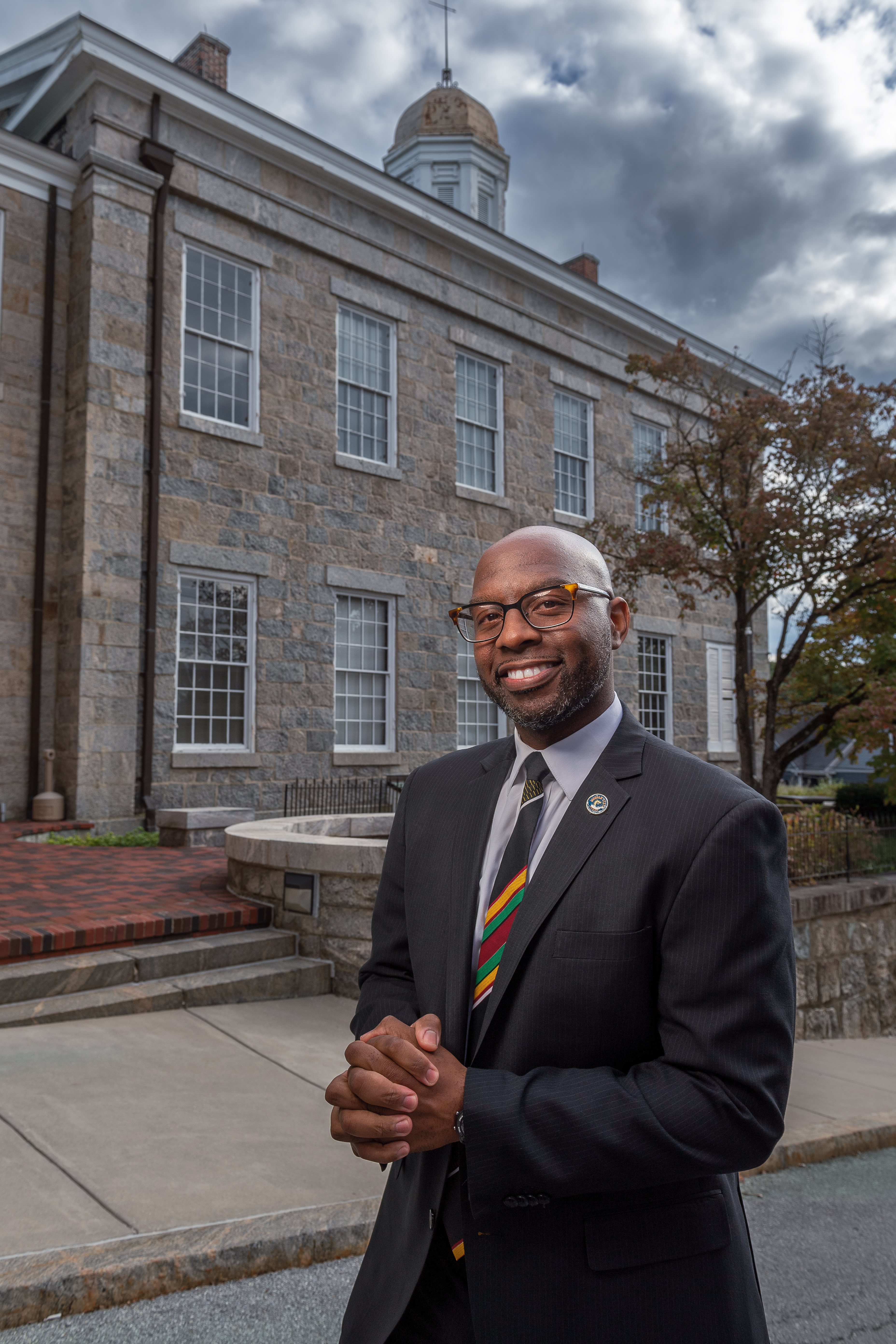 Marcus Nicks, dressed in a grey suit and striped tie, stands out
