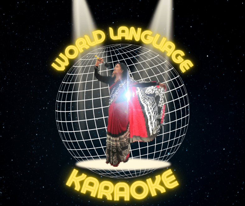 The photograph depicts a woman in traditional Indian clothing of red, black, white, holding a microphone with arm outstretched as if belting out a song. She stands in two spotlights shining on her from above, and in front of a representation of the globe with the words "World Language Karaoke" surrounding the globe in yellow. All of this is against a backdrop of twinkling stars against in the darkness of outer space.