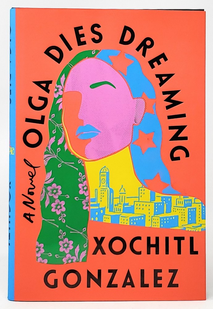A bright red cover features a color-block illustration of a woman's face in pink, with patterns of stars and flowers in her hair, all resting above a yellow and blue cityscape.