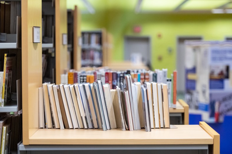 View of a line of stacks at the library, with books displayed atop.