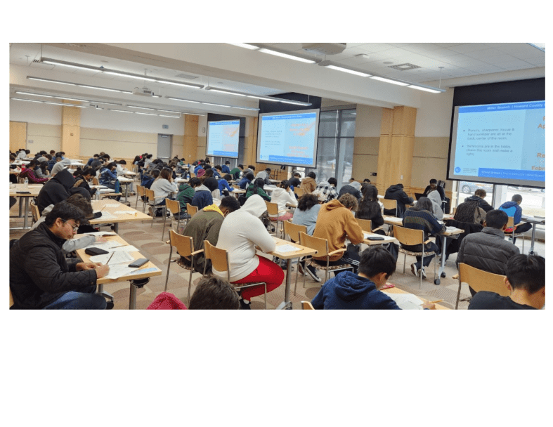 The photograph shows students in an SAT test prep class at HCLS Miller Branch taking the practice test in three meeting rooms.
