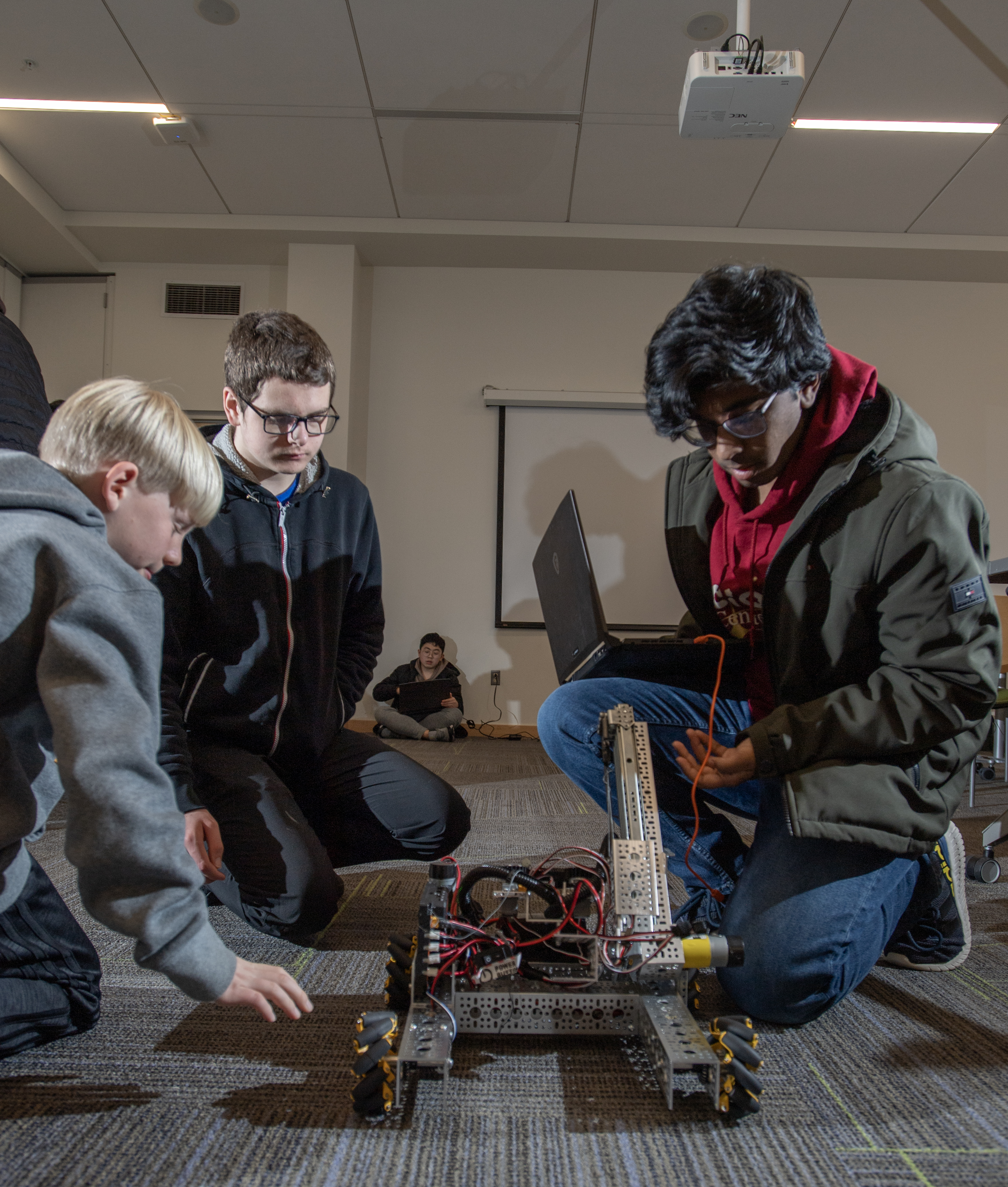 Teens working together to test their simple robot.