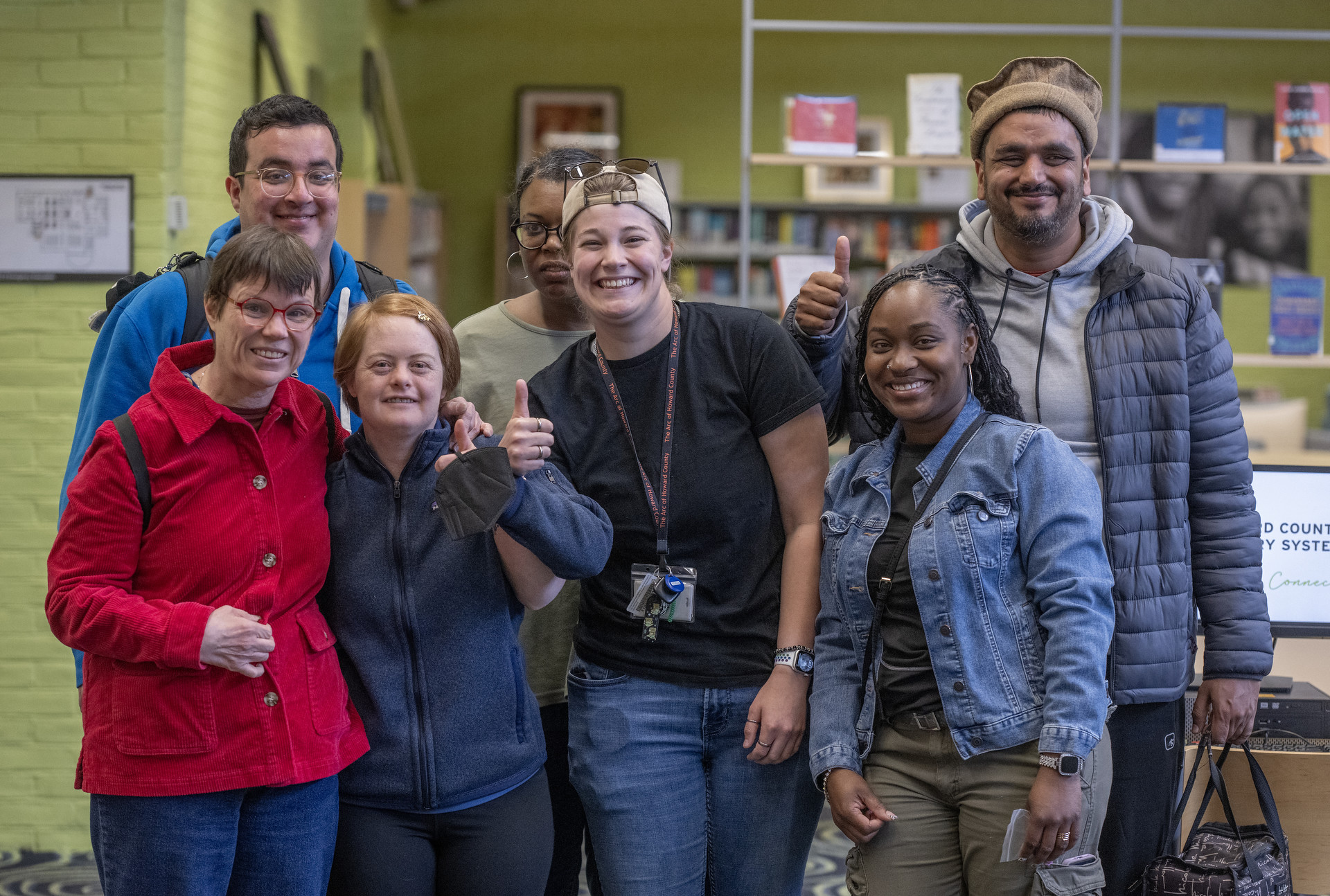 A smiling group of six people stand inside the library.