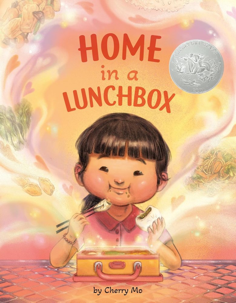 A child surrounded by steam full of food items eats lunch with chopsticks in one hand and a bun in the other.