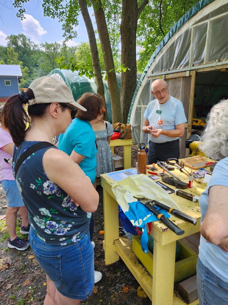 A volunteer fixer teaches community members about tool repair.